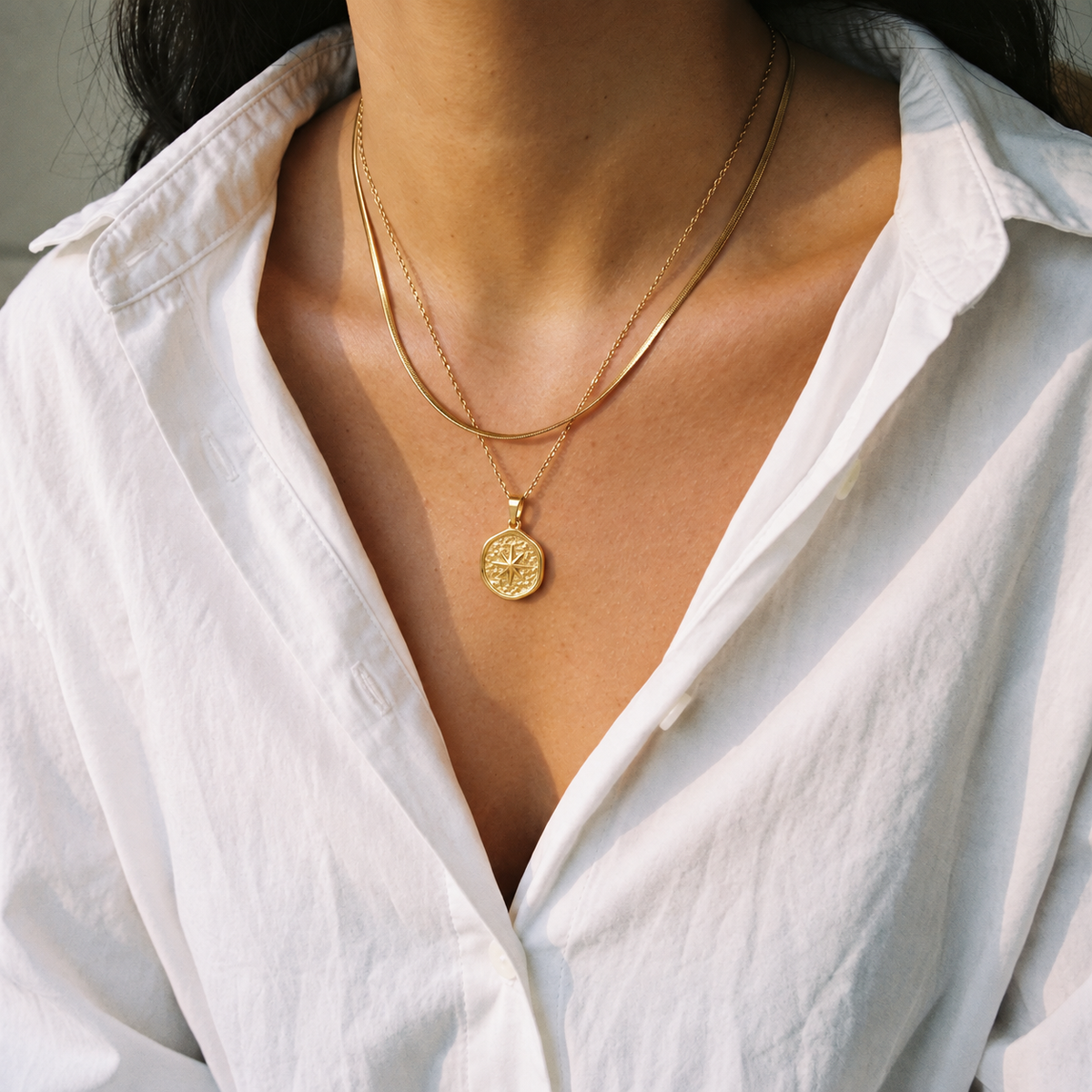 Gold snake chain necklace layered with the Étoile pendant necklace, worn with a white shirt