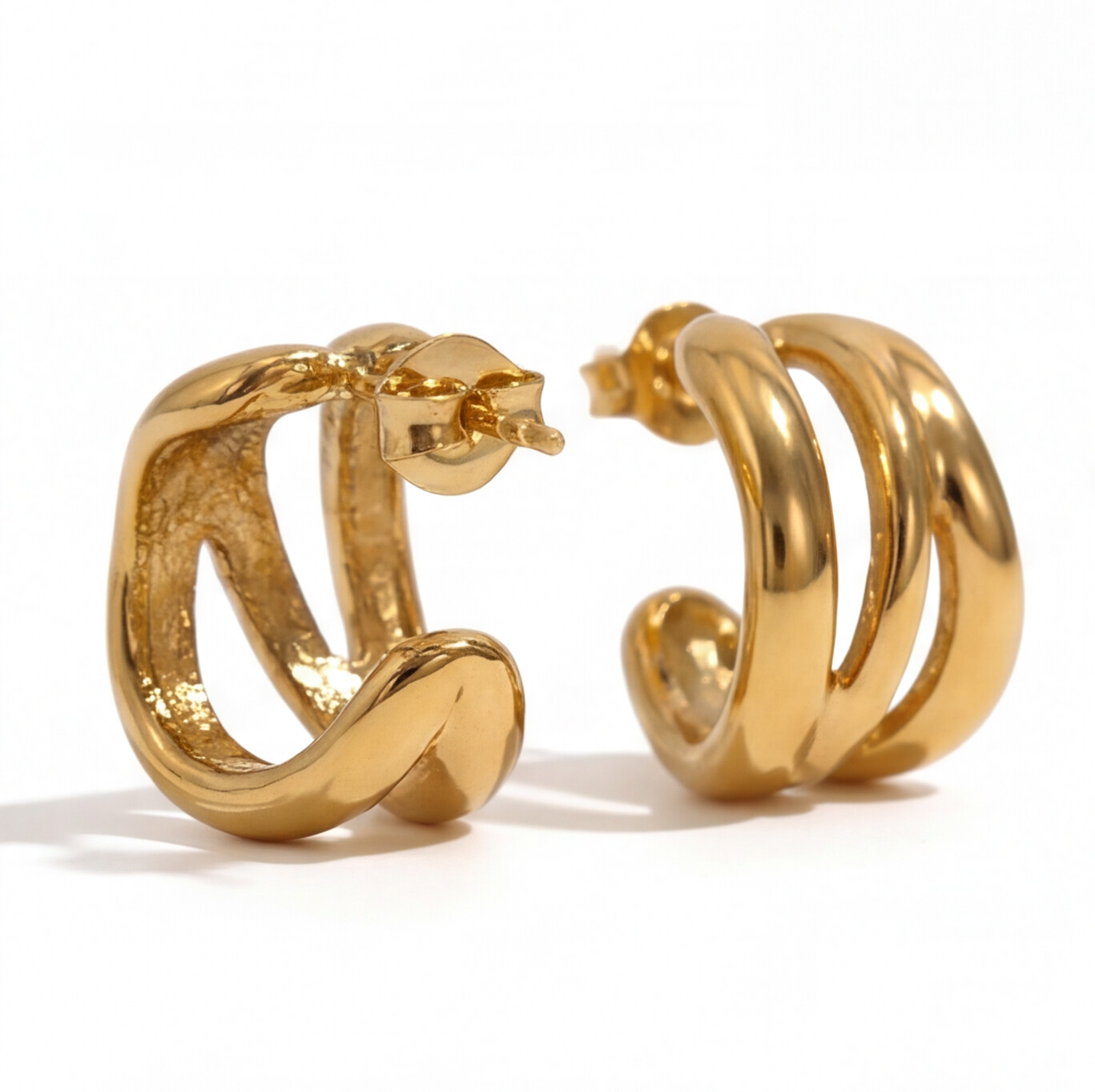 A pair of gold hoop earrings with a twisted, open design, shown on a clean white background.